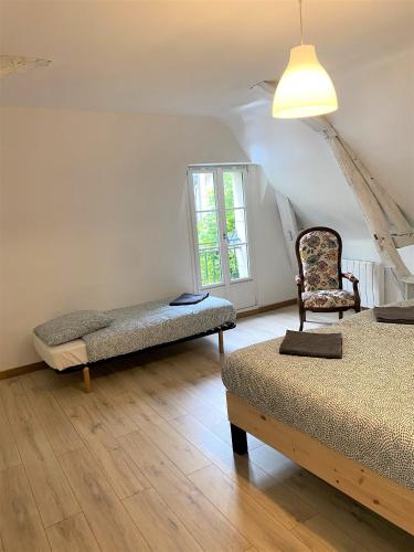 une chambre avec deux lits et une chaise et une fenêtre dans l'établissement LE CHANT DES OISEAUX, 3Km du Zoo de Beauval, Parking gratuit ,WIFI et NETFLIX gratuits, à Saint-Aignan