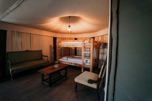 a room with a bunk bed and a couch and a table at Green Fields - Durbuy in Durbuy