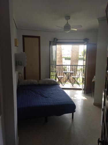 a bedroom with a bed and a view of a balcony at Estudio Sota-Piscina in Denia