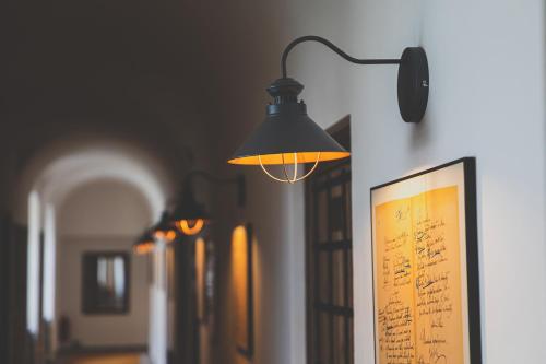 a lamp hanging on a wall with a sheet music at Penzion Šatlava in Nové Město nad Metují
