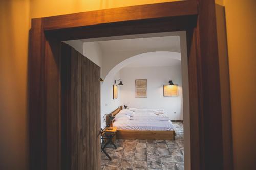 a bedroom with a bed and an open doorway at Penzion Šatlava in Nové Město nad Metují