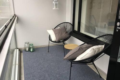 2 Stühle mit Kissen in einem Zimmer mit Fenster in der Unterkunft MODERNI YKSIÖ HUIPPUSIJAINNILLA! in Lempäälä