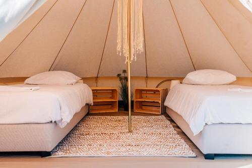 a room with two beds and a rug in a tent at Green Fields - Durbuy in Durbuy