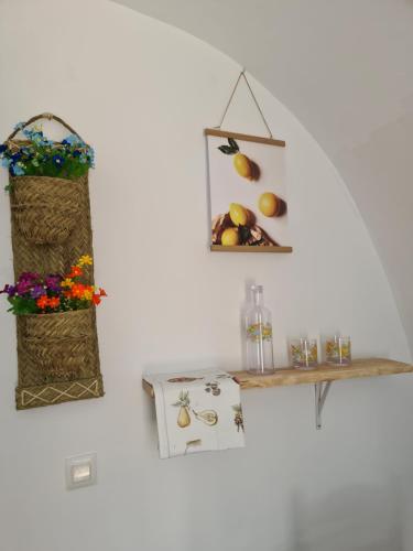 a white wall with two shelves and a table with fruit at White Fish Mojacar in Mojácar