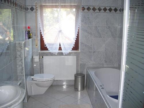 ein Badezimmer mit einem WC, einer Badewanne und einem Waschbecken in der Unterkunft Ferienwohnung Serr in Lauf
