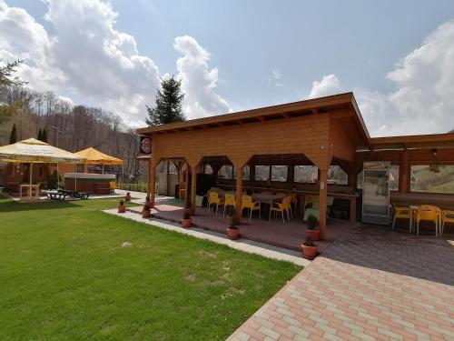 a pavilion with tables and chairs in a yard at Pensiunea Colt Alb in Băile Homorod