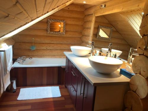 a bathroom with two sinks and a bath tub at L'Edelweiss in Allos