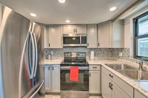 a kitchen with white cabinets and a stainless steel refrigerator at Bright Venice Home with Yard Less Than 4 Miles to Beach! in Venice