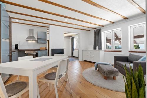 a kitchen and living room with a white table and chairs at Second Home - Ferienwohnungen Fischbach in Friedrichshafen