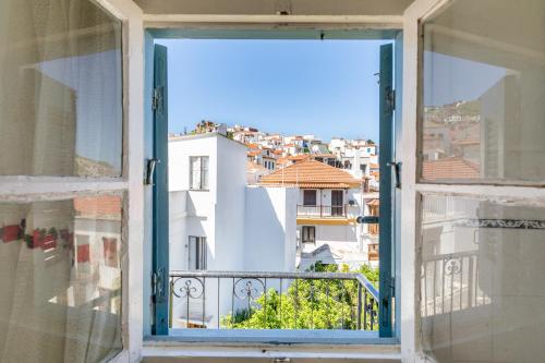 an open window with a view of a city at Yiayia's guesthouse in Skopelos Town