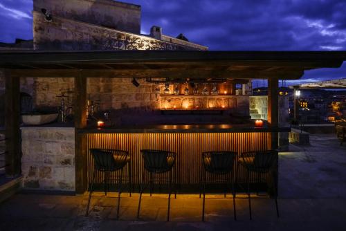 a bar with chairs in front of a building at night at Luvi Cave Hotel in Goreme