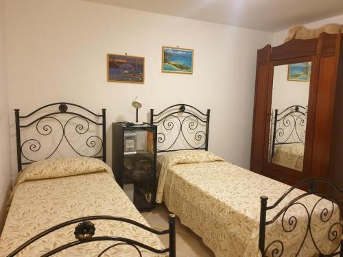 1 dormitorio con 2 camas y espejo en Villa Arisa with pool, en Selva di Fasano