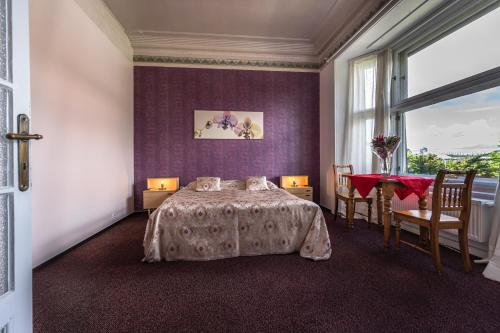 1 dormitorio con cama, mesa y ventana en Historic Villa "Imperia" en Praga