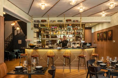 a man standing behind a bar in a restaurant at HAB Hotel Bogotá in Bogotá