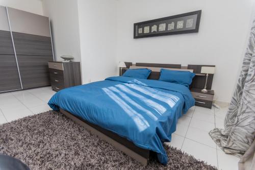 1 dormitorio con cama azul y almohadas azules en Appartement à 700m gare centrale/plage en Pointe-Noire