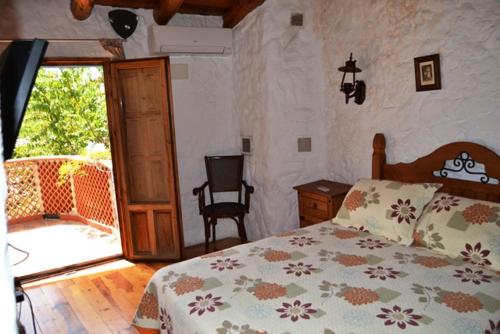 1 dormitorio con 1 cama y puerta corredera de cristal en Casas Rurales La Tejeruela, en Yeste