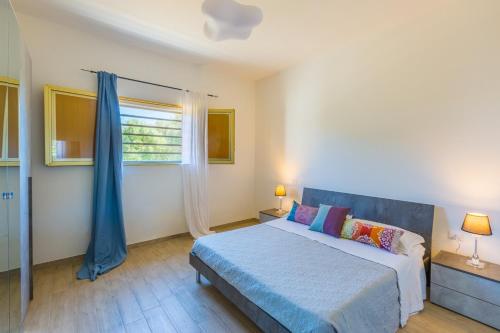 a bedroom with a bed and a window at Villa Euframia in San Vito dei Normanni