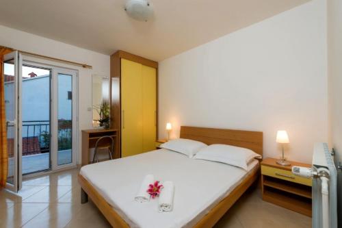 Apartment in Bol with Seaview, Balcony, Air condition, WIFI (156-9) في بول: غرفة نوم بسرير ابيض كبير عليها ورد