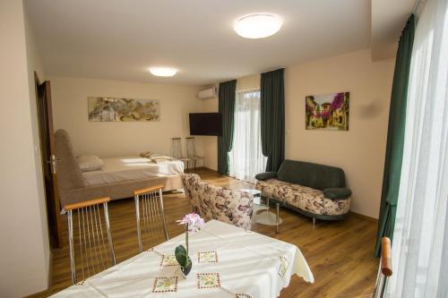 ein Zimmer mit einem Bett und einem Tisch mit Blumen darauf in der Unterkunft Guest apartments STELA in Zarewo