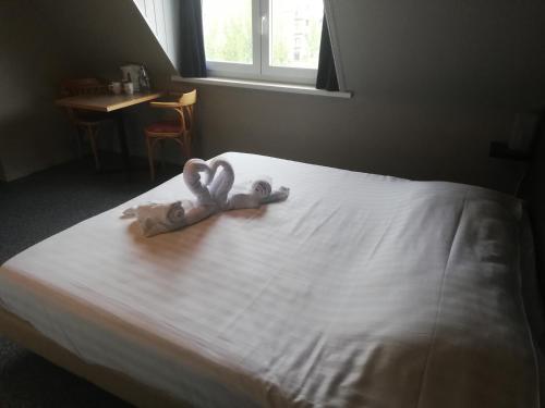 zwei Handtücher in Form von Herzen auf einem Bett in der Unterkunft Logies Het Maantje in De Panne