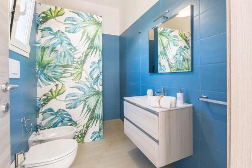 a blue bathroom with a toilet and a sink at Villa Euframia in San Vito dei Normanni