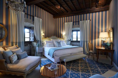 Un dormitorio con una cama, un sofá y una silla. en Helguera Palacio Boutique & Antique, en Torrelavega