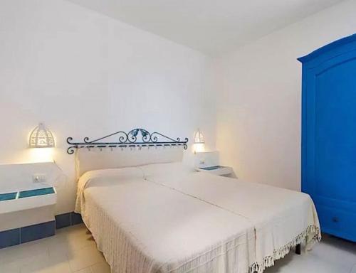 a bedroom with a white bed and a blue cabinet at Magnificent Villa: SUPER PANORAMIC in Costa Rei