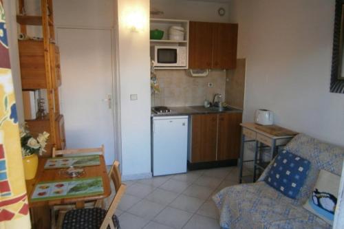 Elle comprend une petite cuisine équipée d'un réfrigérateur blanc et d'une table. dans l'établissement Comfortable Flat With Balcony Cannes City Centre, à Cannes