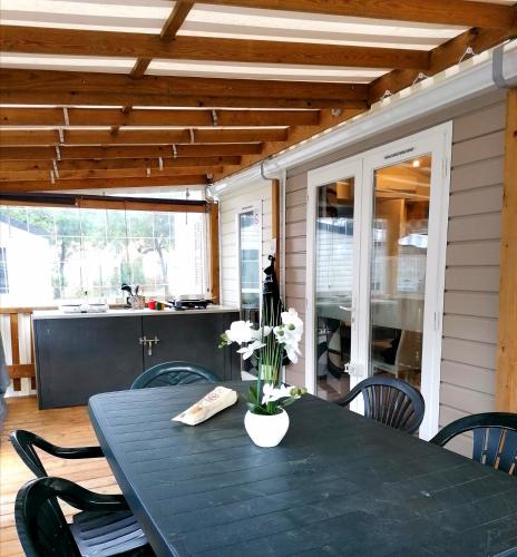 une table de salle à manger avec un vase de fleurs dessus dans l'établissement la pignade, à La Tremblade