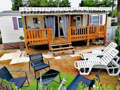 une maison dotée d'une terrasse avec des chaises et une table dans l'établissement la pignade, à La Tremblade