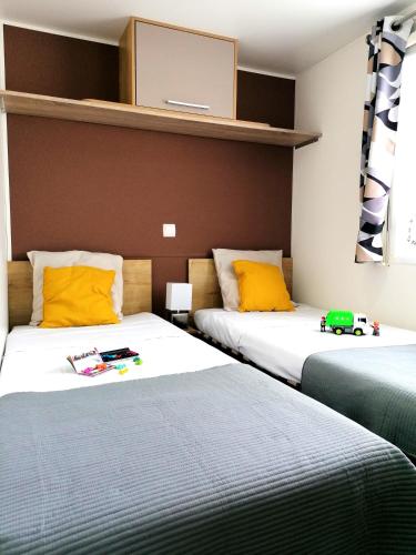 deux lits côte à côte dans une pièce dans l'établissement la pignade, à La Tremblade