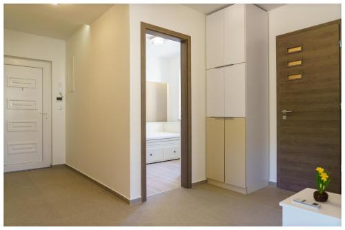 korytarz z drzwiami prowadzącymi do łazienki w obiekcie Kenese Regatta Apartman w mieście Balatonkenese