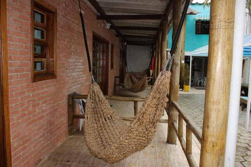 two hammocks hanging on a porch of a building at Chales Marissol in Ubatuba