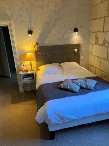 ein Schlafzimmer mit einem Bett mit zwei Kissen darauf in der Unterkunft Logis Hôtel Auberge De L'ecole in Pontlevoy