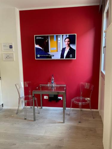 una pared roja con una mesa y una TV. en A&F Apartment Padova centro storico, en Padua