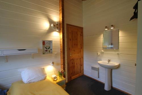 a bathroom with a bed and a sink in a room at Charmant Chalet LE DAMELI, Village du Soleil, Chalet 61 in Mauroux