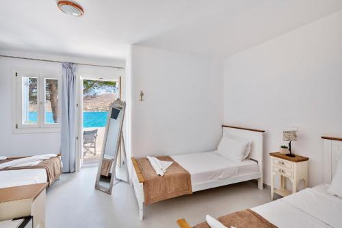 ein Schlafzimmer mit zwei Betten und einem Fenster in der Unterkunft Di Mare in Posidhonía