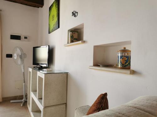 a room with a bed and a tv on a wall at Appartamento Geco Rosso in Noto Marina
