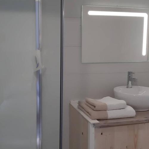 une salle de bain blanche avec un lavabo et un miroir dans l'établissement Relais Saint Vincent, à Thonville