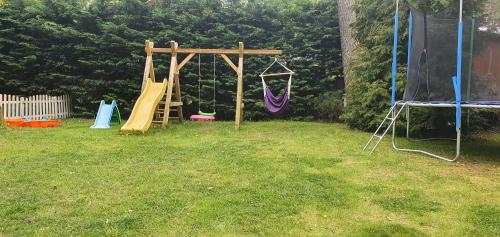 a playground in a yard with a swing at Domki u Remika in Pobierowo