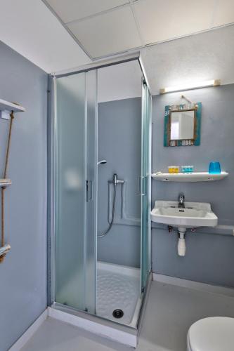 ein Badezimmer mit Glasdusche und Waschbecken in der Unterkunft Di Mare in Posidhonía