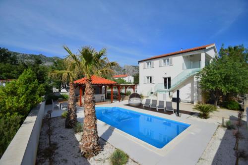 a swimming pool in front of a house at Villa Golden Apple in Seline