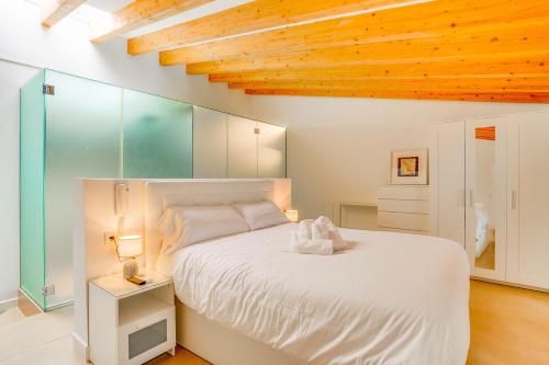 een slaapkamer met een wit bed en een houten plafond bij Duplex Palma Apartment - with garage in Palma de Mallorca