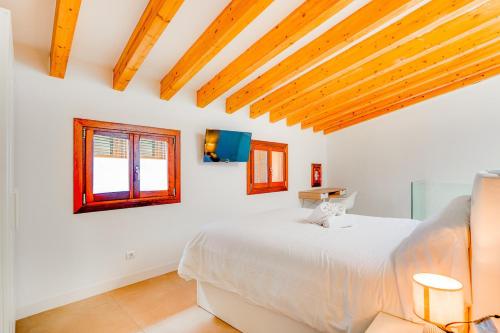 a white bedroom with a bed and two windows at Duplex Palma Apartment - with garage in Palma de Mallorca
