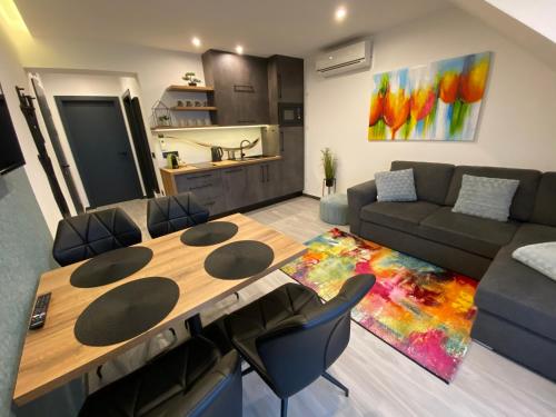 a living room with a table and a couch at Luxury Apartments Keszthely in Keszthely