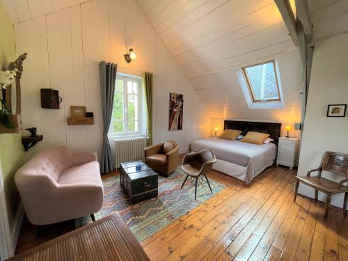 a bedroom with a bed and a couch and a chair at Chambres d'Hôtes Couleurs du Temps in Périgueux