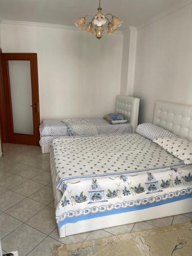 2 łóżka pojedyncze w sypialni z lustrem w obiekcie Eldi's Apartment w mieście Shëngjin