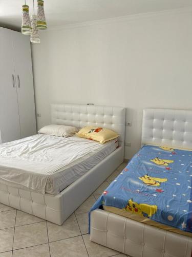 sypialnia z dużym białym łóżkiem z materacem w obiekcie Eldi's Apartment w mieście Shëngjin