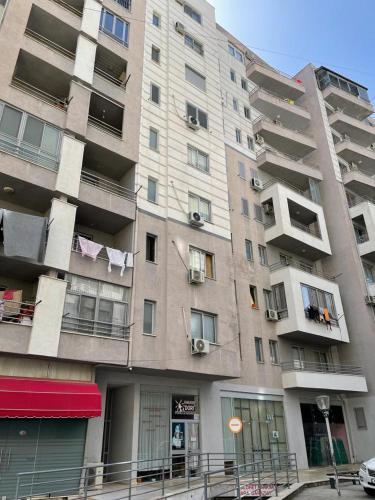 duży apartamentowiec z ubraniami wiszącymi na balkonie w obiekcie Eldi's Apartment w mieście Shëngjin