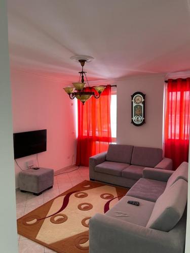 salon z kanapą i telewizorem w obiekcie Eldi's Apartment w mieście Shëngjin